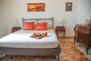 a bedroom with a bed with a tray of fruit on it at Soffio del Libeccio B&B in Syracuse