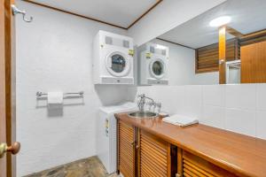 y baño con lavabo y lavadora. en Absolute beachfront, heart of Port Douglas - 24 S, en Port Douglas