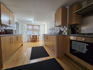 una cocina con armarios de madera y una mesa. en ALLARDYCE, en Kincardine