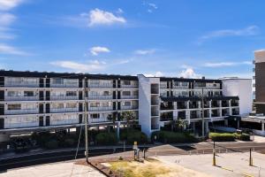 a large apartment building with a parking lot at Sea La Vie on the Boardwalk in Carolina Beach