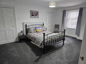 ein Schlafzimmer mit einem Bett in einem weißen Zimmer in der Unterkunft ALLARDYCE in Kincardine