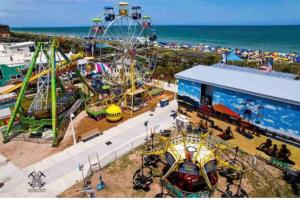 an amusement park with a ferris wheel and a carnival at Sea La Vie on the Boardwalk in Carolina Beach