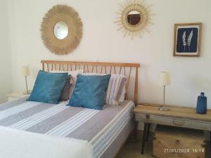 1 dormitorio con cama con almohadas azules y espejo en SAO RAFAEL TRADICIONAL BEACH APARTMENT, en Albufeira