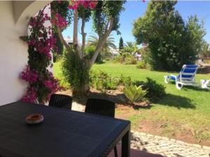 una mesa y sillas en un patio con flores en SAO RAFAEL TRADICIONAL BEACH APARTMENT, en Albufeira