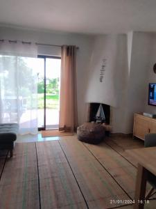sala de estar con chimenea y ventana grande en SAO RAFAEL TRADICIONAL BEACH APARTMENT, en Albufeira