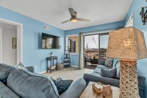 a blue living room with a couch and a ceiling fan at Seas The Day with Fantastic Marina Views in Carolina Beach