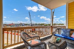 a balcony with chairs and a couch and a view of a harbor at Seas The Day with Fantastic Marina Views in Carolina Beach