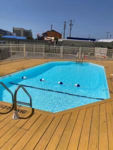 a large blue swimming pool on a wooden deck at Seas The Day with Fantastic Marina Views in Carolina Beach