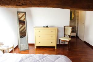a bedroom with a dresser and a mirror and a chair at Sant'Agata in Ravenna