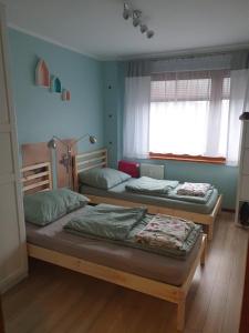 two twin beds in a room with a window at Apartament Daria in Jaworzno