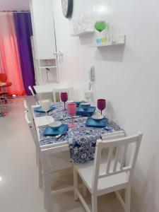einen Esstisch mit Stühlen und Rotweingläsern in der Unterkunft Spring Tree Place in Baguio City