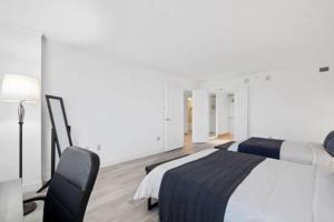 Un dormitorio con una cama, un escritorio y una lámpara. en Huge 2BR 3BA Ocean Front Condo by CozySuites, en Atlantic City