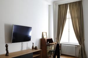 a living room with a flat screen tv and two windows at Premium Class Apartments III in Zagreb