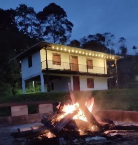 a fire in front of a house at night at Kiota - casa completa - 74 m2 in Jardin