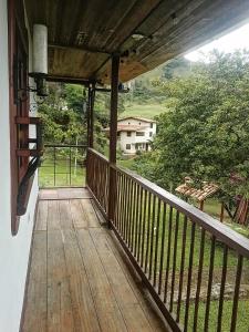a wooden porch with a view of a house at Kiota - casa completa - 74 m2 in Jardin