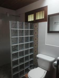 a bathroom with a toilet and a tile wall at Kiota - casa completa - 74 m2 in Jardin