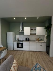una cocina con armarios blancos y un sofá en una habitación en La chambre turquoise, en Amiens