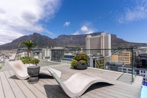 a balcony with chairs and a view of a city at The Tokyo 710 in Cape Town