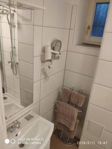 a white bathroom with a sink and a shower at Budget dbl Studio free breakfast in Ljubljana