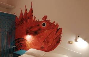 Relais Al Faro Bed&Breakfast في سان دومينو: غرفة نوم مع تنين احمر على الحائط