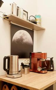 a kitchen counter with a coffee maker on a shelf at Explorer Apartment Düsseldorf in Düsseldorf