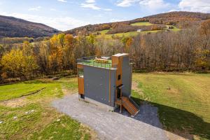 an overhead view of a tiny house in a field at Modern Catskill House & Lake NY with hot tube on the roof in Stamford