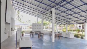 un patio con muebles blancos, mesas y sillas en DIVERSITY HOTEL en Sosúa