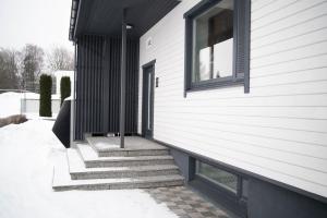 Biały dom ze schodami obok okna w obiekcie good mood guesthouse w mieście Otepää