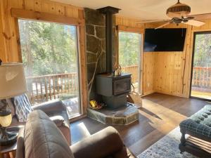 a living room with a fireplace and a stove at Cozy Cabin Retreat in Ponderosa
