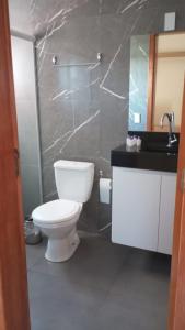 uma casa de banho com um WC branco e um lavatório. em HOTEL BARLOS ADUANA em Uruguaiana