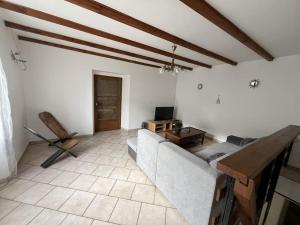 a living room with a couch and a tv at Maison proche de la campagne au calme 7-8 personnes in Cambon