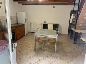 a kitchen with a table and chairs in a room at Maison proche de la campagne au calme 7-8 personnes in Cambon +3 photos
