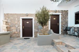 a patio with two doors and a tree in a planter at Aegean Moments in Glinado Naxos