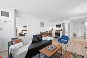 a living room with a black couch and a blue chair at CozySuites at Showboat Bold 2BR 3BA Beachfront in Atlantic City