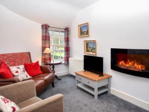 een woonkamer met een bank en een open haard bij 1 Bed in Keswick 86247 in Rosthwaite