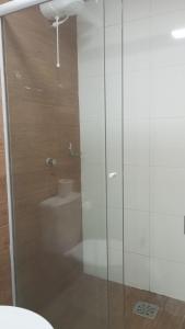 a bathroom with a glass shower with a toilet at HOTEL BARLOS ADUANA in Uruguaiana
