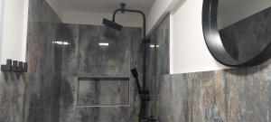 La salle de bains est pourvue d'une douche avec un miroir mural. dans l'établissement Apartmány Javorek, à Sněžné
