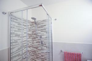 a shower with a glass door in a bathroom at Soffio del Libeccio B&B in Syracuse