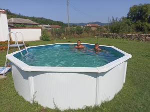 two people in a hot tub in a yard at Къща Ралица in Chakalarovo