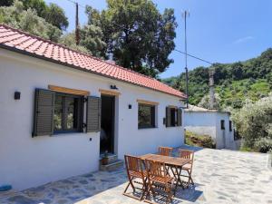 a patio with a table and chairs in front of a house at Fofi's House in Agii Saranta
