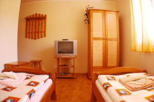 a room with two beds and a television at Penzion Majak in Banská Bystrica