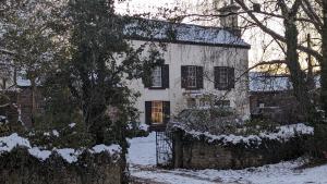 a white house with snow on the ground at Fairy Cottage in Lea