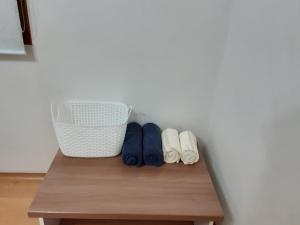 a table with three pairs of shoes and a basket at Camp Humphreys pyeongtaek's sharing house in Pyeongtaek
