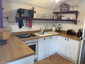 a kitchen with white cabinets and a counter top at The Plover in Blakeney