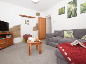 a living room with a couch and a tv and a table at 2 Bed in Lydbrook 83665 in Lydbrook