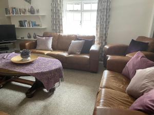 a living room with two couches and a table at The Plover in Blakeney