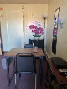 Midtown Inn & Suites في La Junta: مكتب فيه طاولة وكراسي وورود على الحائط