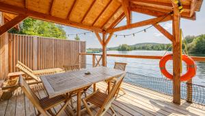 a wooden deck with a table and chairs at Lieu Dieu, Domaine de Campagne in Beauchamps