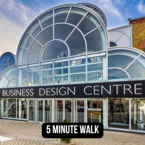 a glass building with a minute walk sign in front at Chapel Manor Large 2 Bed Flat Zone 1 in London