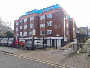 a brick building with cars parked in front of it at Neon Heights 2 bed Luton town centre in Luton